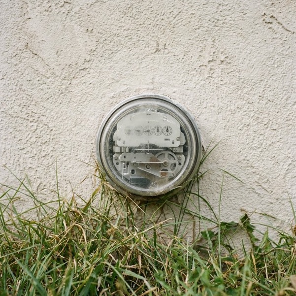 A residential electric meter on the side of a house